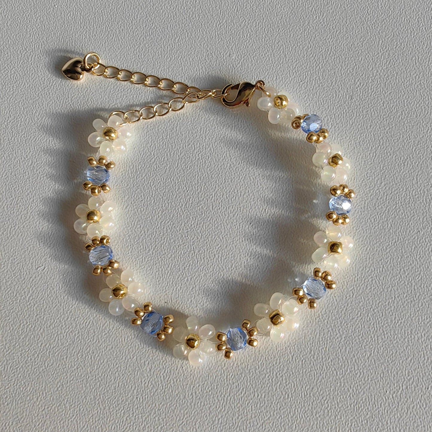 Blue crystal glass bead bracelet with white seed beads on white background