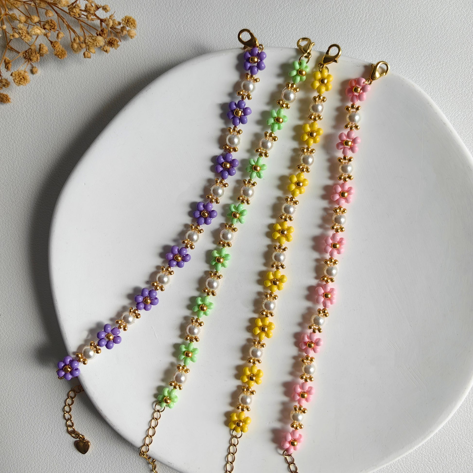 Pearl Blossom Bracelet in pink, purple, green and yellow displayed on a white plate