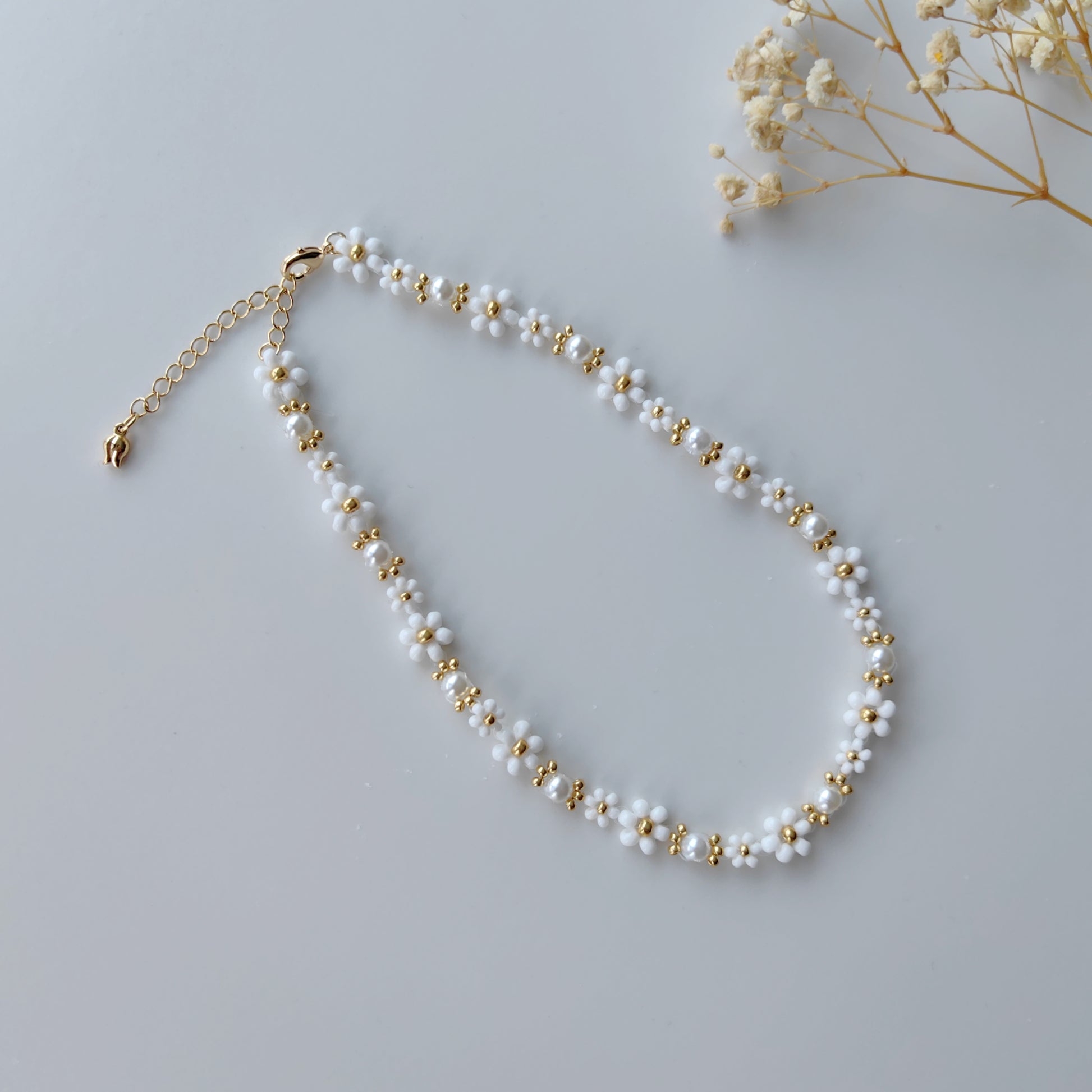 Handmade beaded pearl necklace with 2mm and 3mm seed beads on a white background