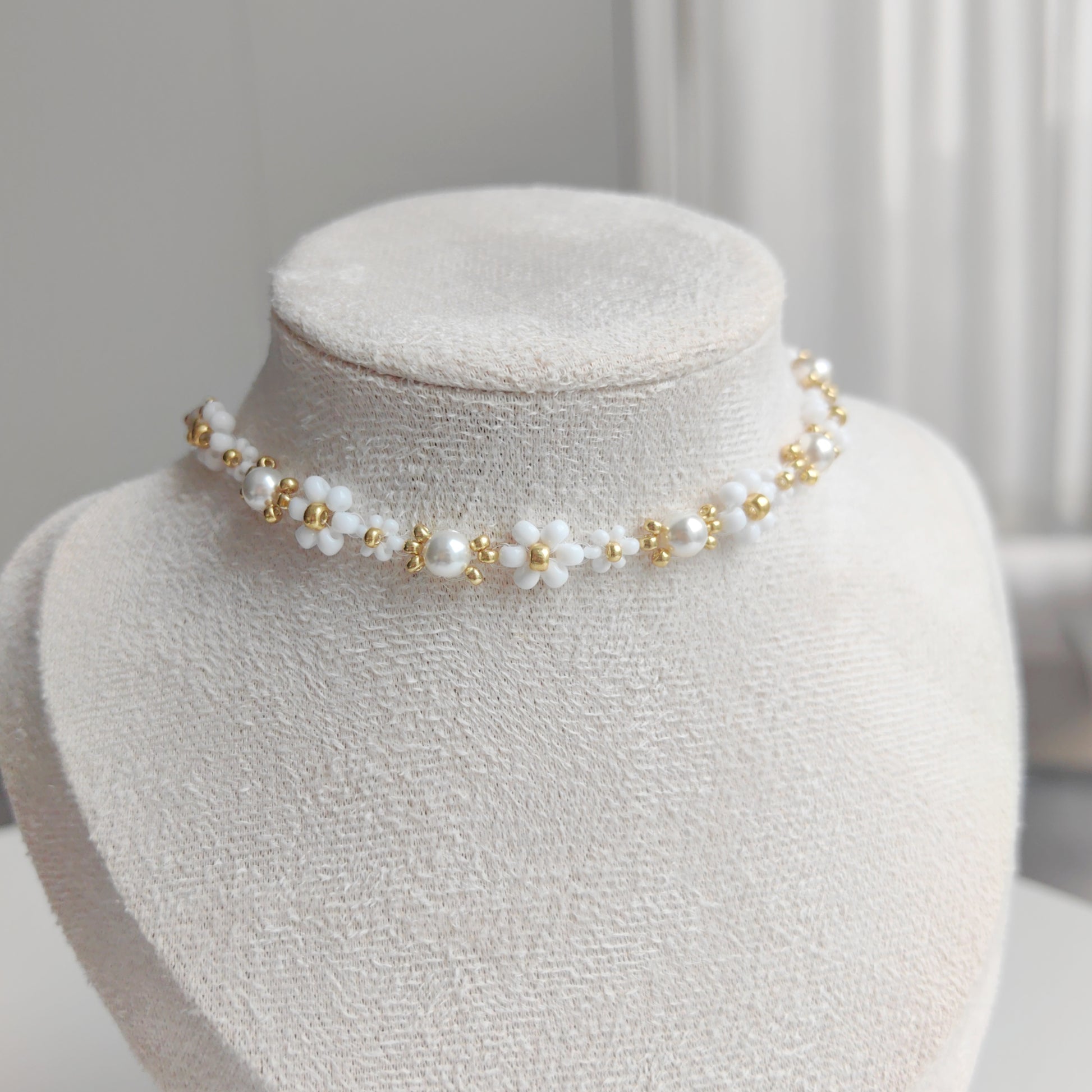 Beaded pearl necklace displayed on a necklace stand