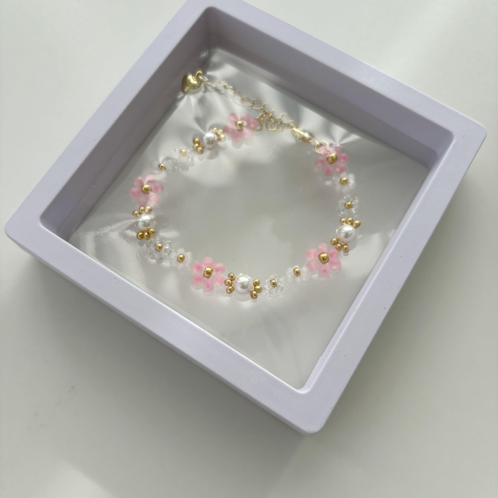 Pink and white beaded pearl bracelet displayed in a jewelry gift box