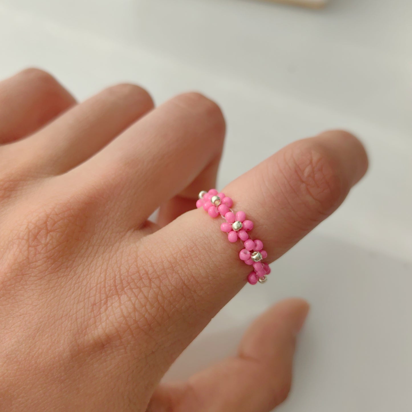 pink beaded flower ring worn on finger