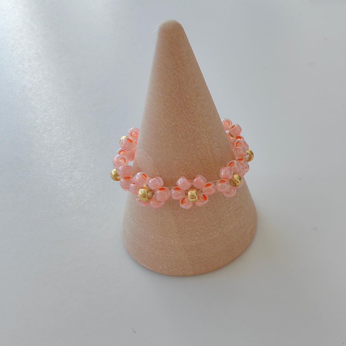 Pink Fairytale 2mm seed bead ring on ring holder display