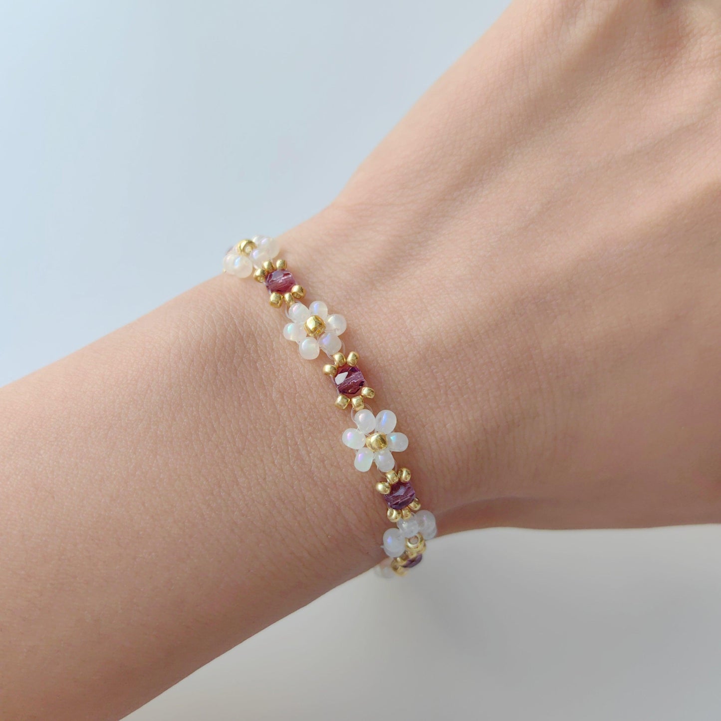 Purple crystal bracelet with white seed beads worn on hand