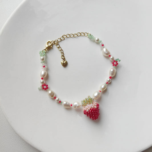 Close-up of strawberry bead bracelet on a white plate, showing bead details