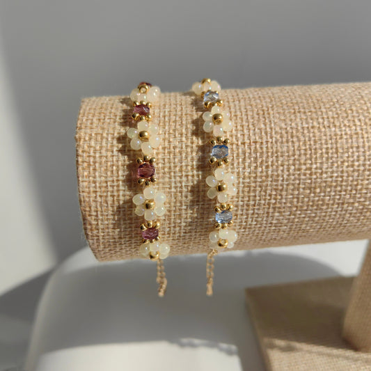 Blue and purple crystal beaded bracelets with white seed beads displayed on bracelet stand