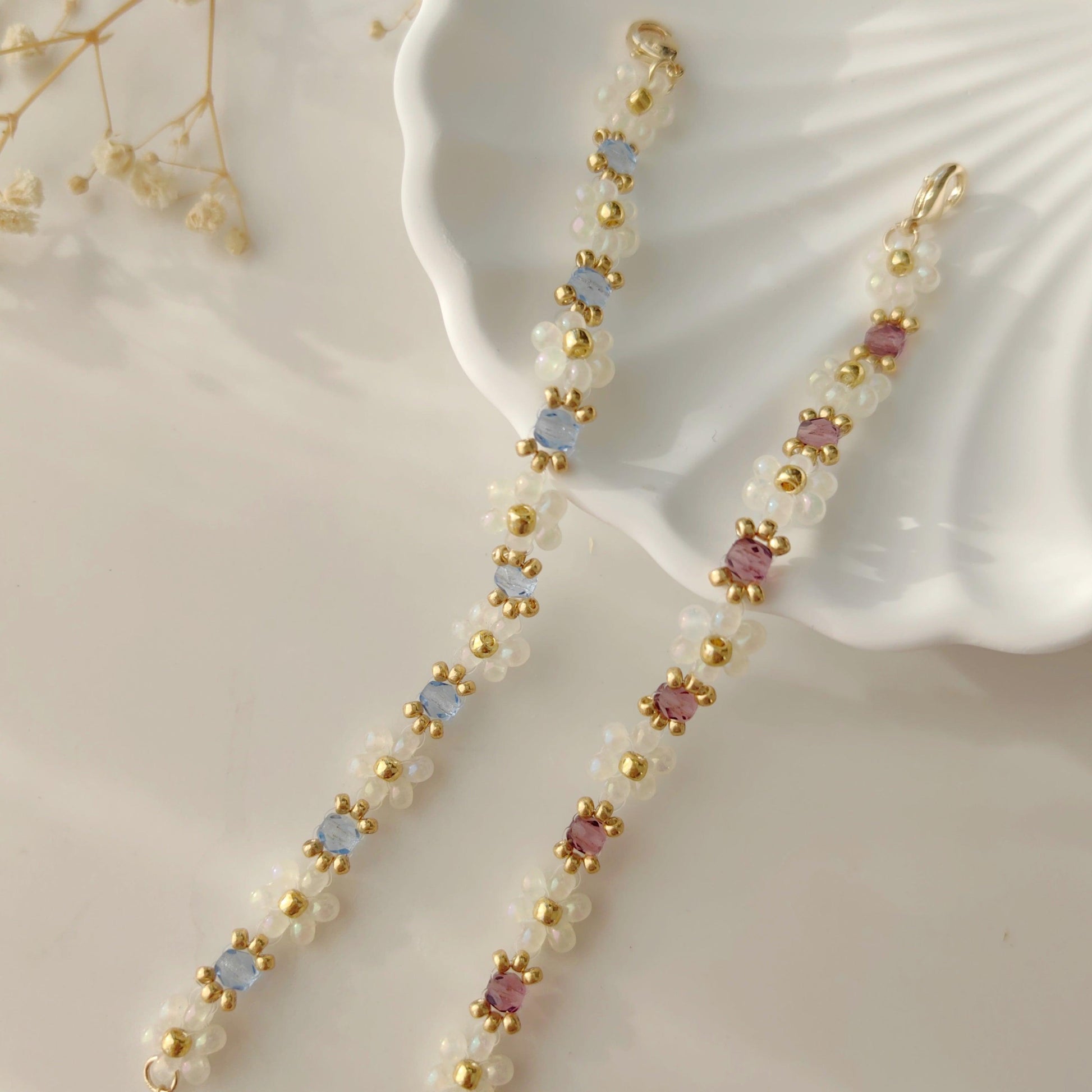 White seed bead crystal bracelets in blue and purple shown on white plate