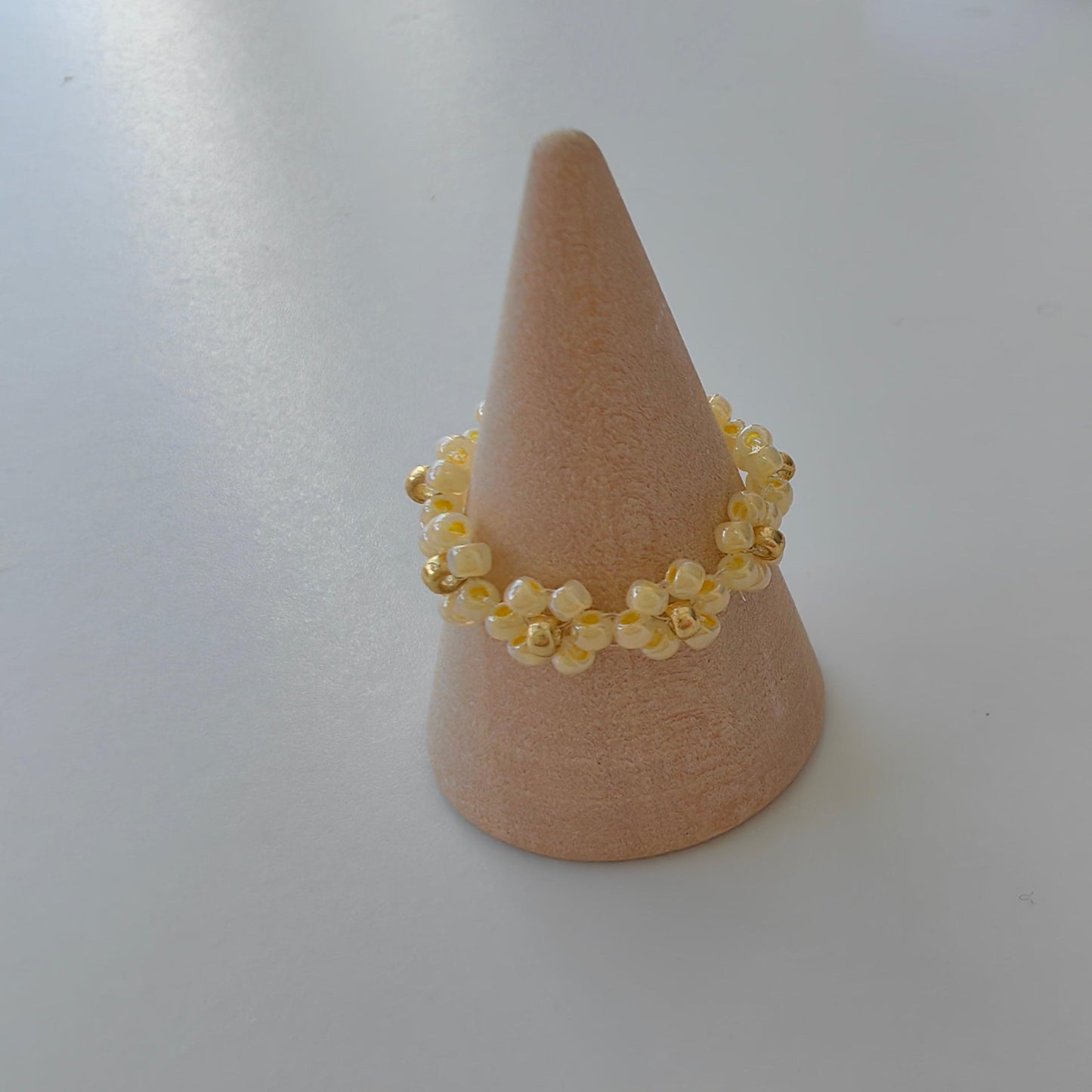 Yellow Fairytale 2mm seed bead ring on jewelry display stand